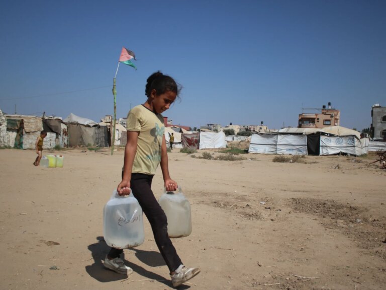 Maysara-carrying-water-back-to-her-familys-tent-2-1787241829.jpg